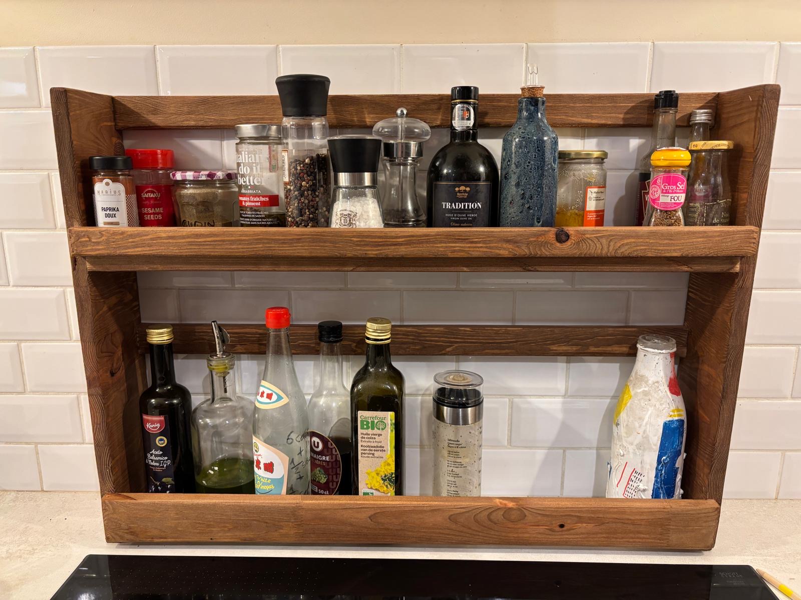 Photo réelle de l’étagère en bois réalisée, remplie de bouteilles et d’épices